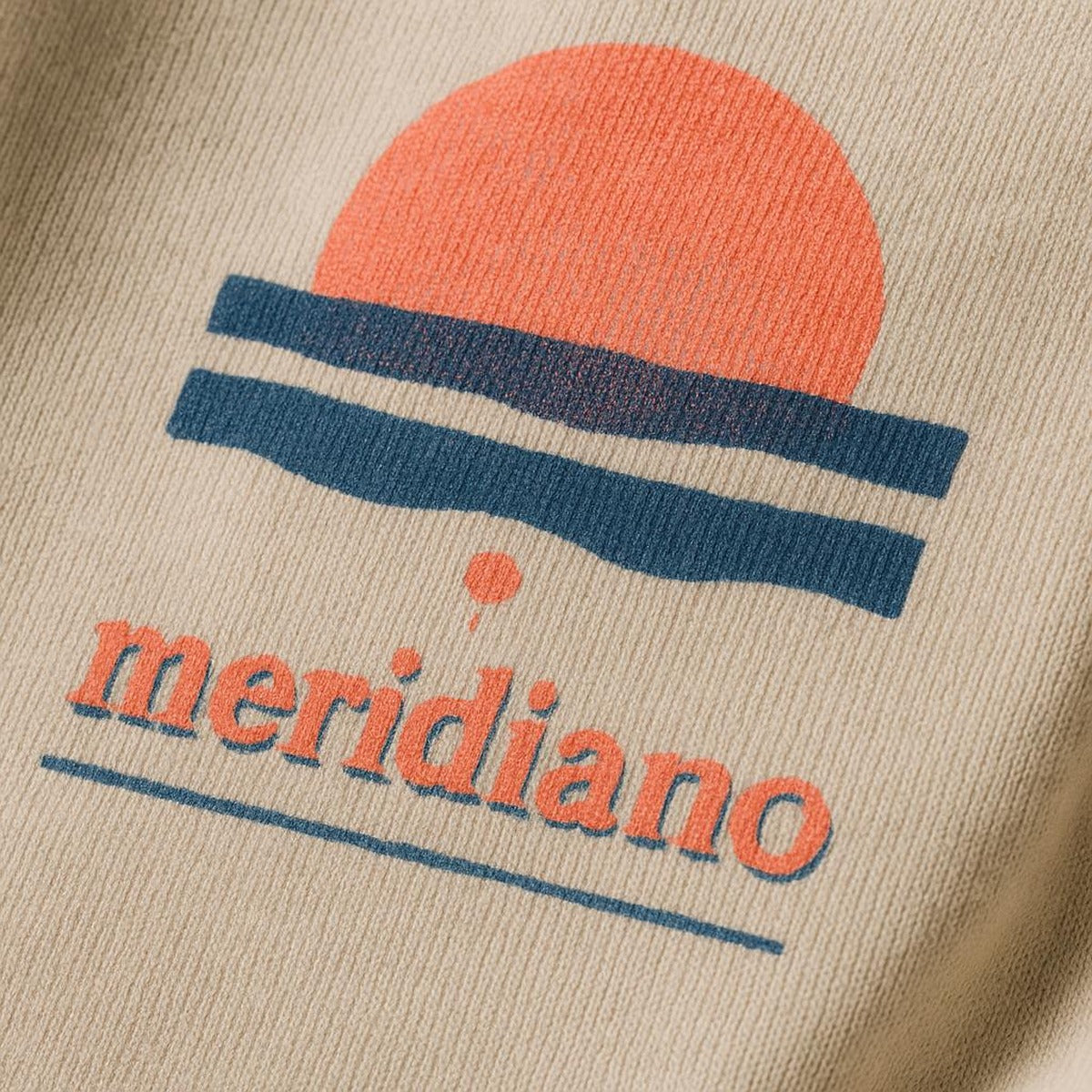 Close-up of the tiny tonal embroidered coastal marker at the hoodie hem