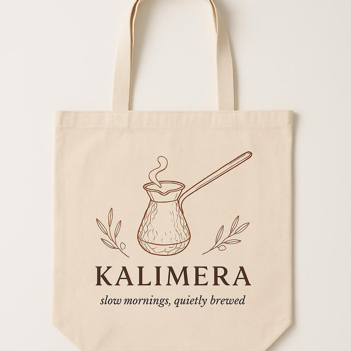 Natural cotton canvas tote bag printed with a copper cezve coffee pot illustration, shown flat against a neutral background