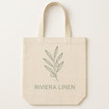 Natural cotton canvas tote bag printed with a muted linen camp-collar shirt design, shown flat against a plain backdrop