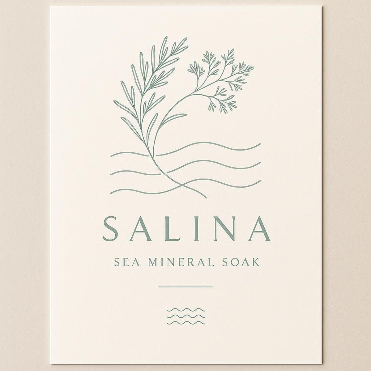 Coastal wellness poster displayed on a pale oak shelf with folded towels and a small dish of sea salt