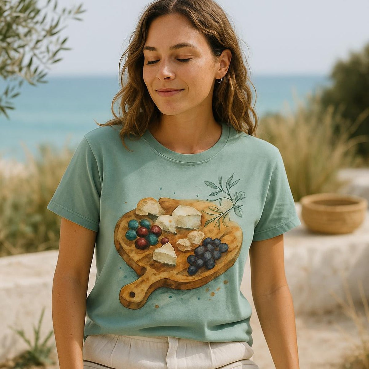 Person wearing the grazing paddle tee at a sunlit Mediterranean lunch table with charcuterie