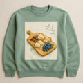 Sage green sweatshirt featuring a hand-drawn olive wood grazing paddle illustration on the chest