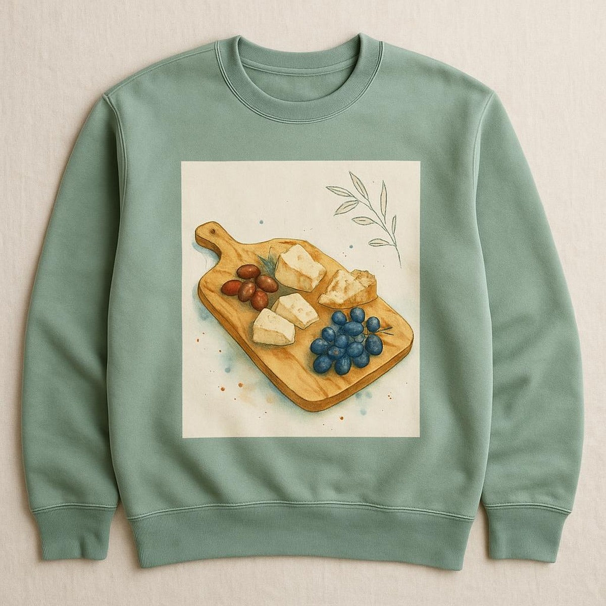 Sage green sweatshirt featuring a hand-drawn olive wood grazing paddle illustration on the chest