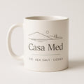 Hand-glazed terracotta ceramic mug with rounded handle on a pale linen surface