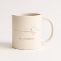 White ceramic mug with a small tonal horizon-and-sun line motif on the front, shown on a plain background